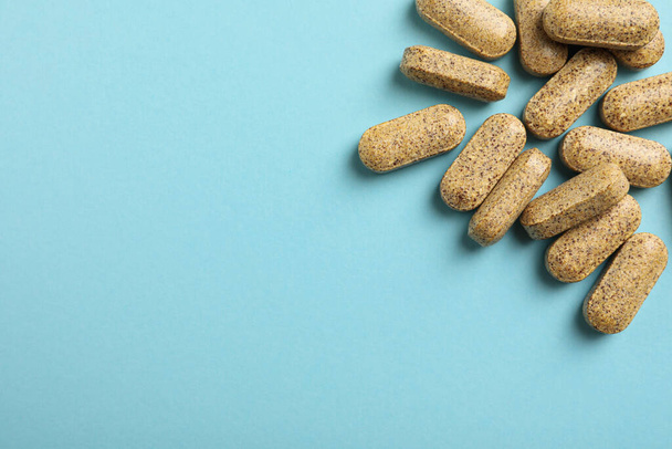 Dietary supplement pills on light blue background, flat lay. Space for text - Valokuva, kuva