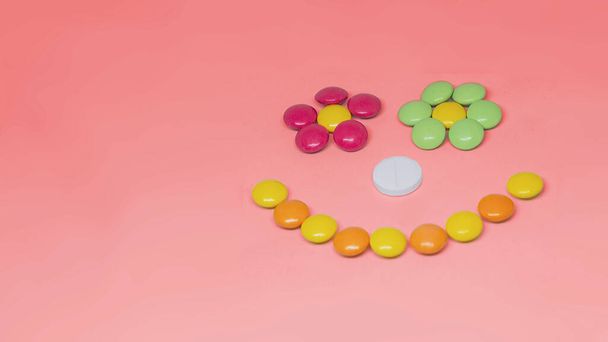 Pills smiley face lying on red background. Space for text. - Photo, Image