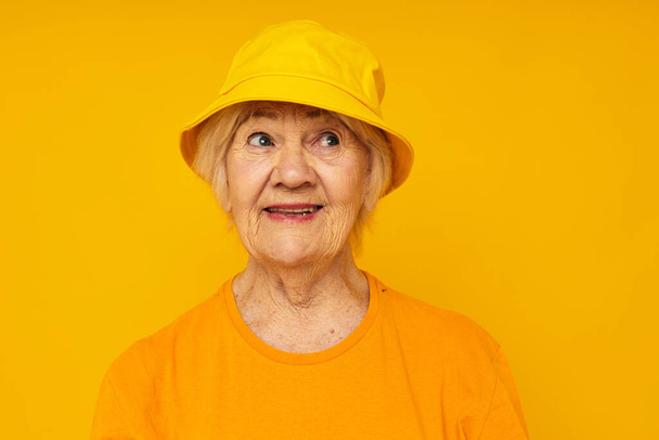 Photo of retired old lady happy lifestyle in a yellow headdress close-up emotions - Fotó, kép