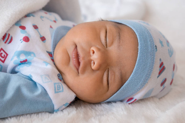 adorável latina bebê masculino tirar uma soneca enquanto deitado e quente com um chapéu e cobertores, estilo de vida infantil em estúdio, amor e resto do membro da família - Foto, Imagem