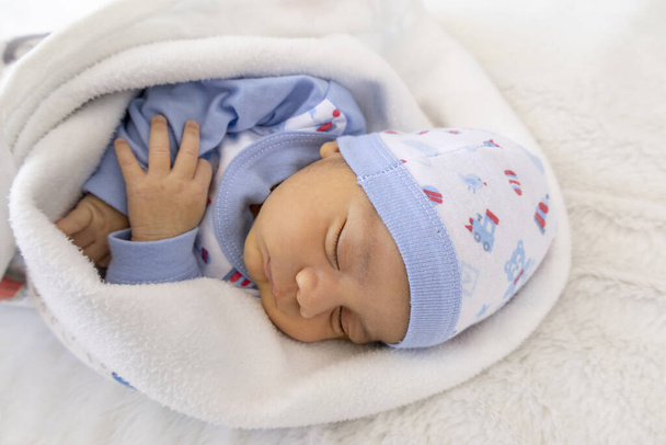 可愛いラテン系男性の赤ちゃんが帽子と毛布で暖かく昼寝をし、スタジオでの幼児生活、新生児ケア、産前産後のケア - 写真・画像