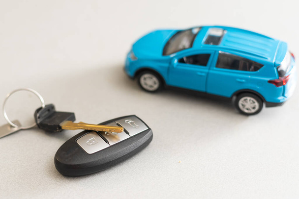 Spielzeugauto und Schlüsselauto auf weißem Hintergrund - Foto, Bild