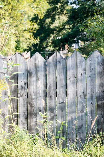starý dřevěný plot s ostnatým drátem na vrcholu - Fotografie, Obrázek