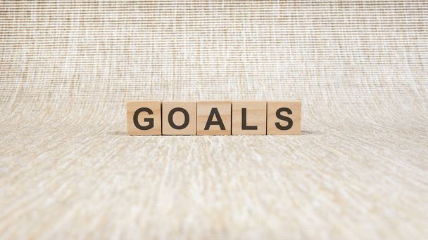 goals written in wooden cubes. conceptual word collected of of wooden elements with the letters. stock image, brown background - Fotoğraf, Görsel