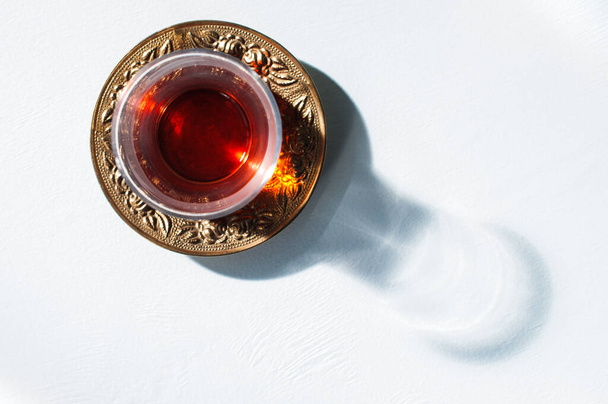 Red tea in glass and hard light with harsh shadows, top view - Fotografie, Obrázek