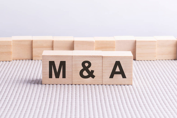 Wooden cube with the letter M and A. gray background. business conceptual word collected of of wooden elements with the letters. - Photo, Image