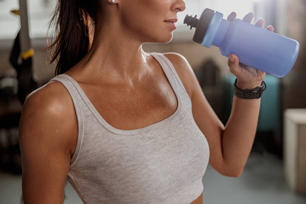 Attractive woman in sports top drinking water - Photo, Image