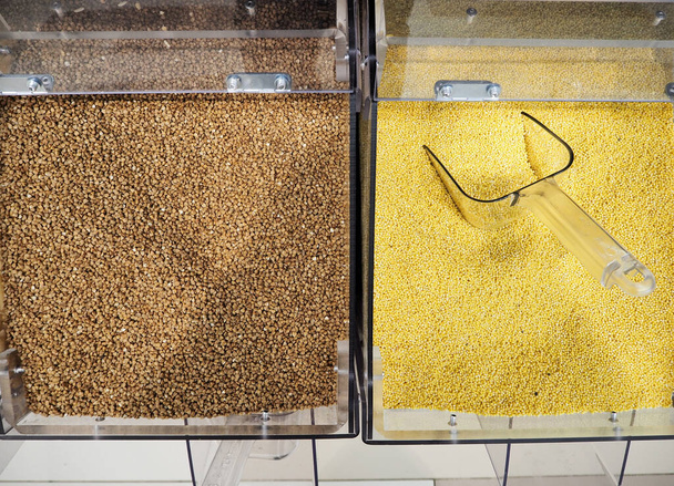 Sale of cereals in the store. Grocery. Buckwheat and millet on the counter in the store. High quality photo - Foto, afbeelding
