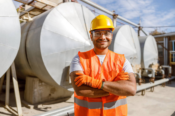 Smiling African engineer standing at industrial site - Foto, afbeelding
