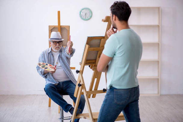 Velho pintor e jovem modelo masculino no estúdio - Foto, Imagem