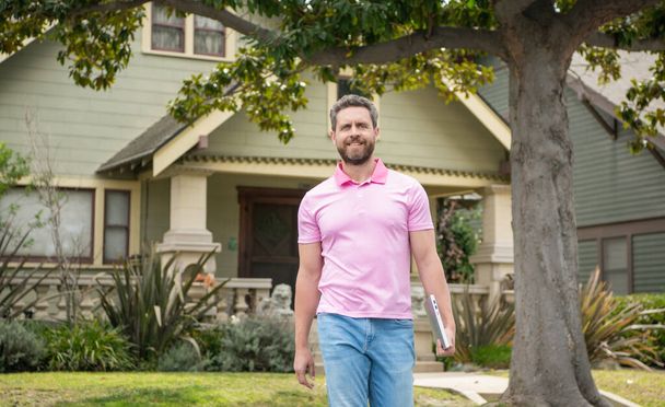 cheerful bearded man real estate agent selling or renting house walk with computer, neighborhood - Photo, Image