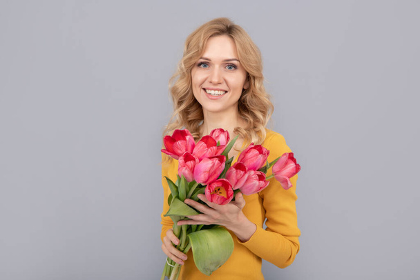 щаслива жінка з тюльпанами. пані тримає квіти для весняного відпочинку. усміхнена дівчина з букетом
 - Фото, зображення