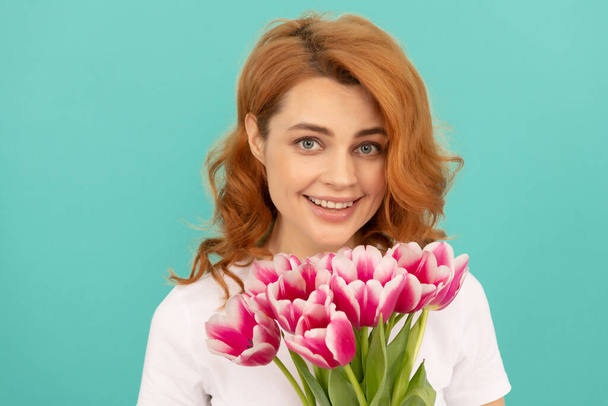 счастливая женщина с цветочным букетом тюльпана на голубом фоне. 8 марта - Фото, изображение