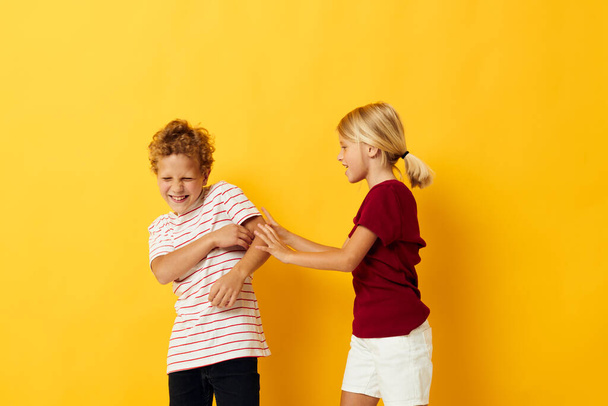 Boy and girl standing side by side posing childhood emotions isolated background - Foto, afbeelding