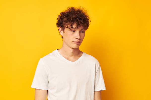 red-haired guy in a white t-shirt on a yellow background - Foto, afbeelding