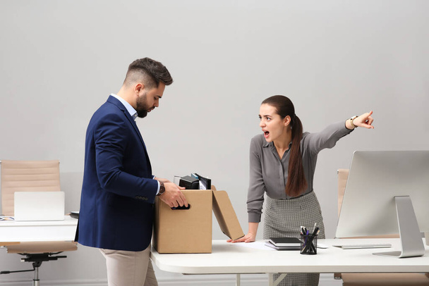 Boss dismissing young man from work in office - Photo, image