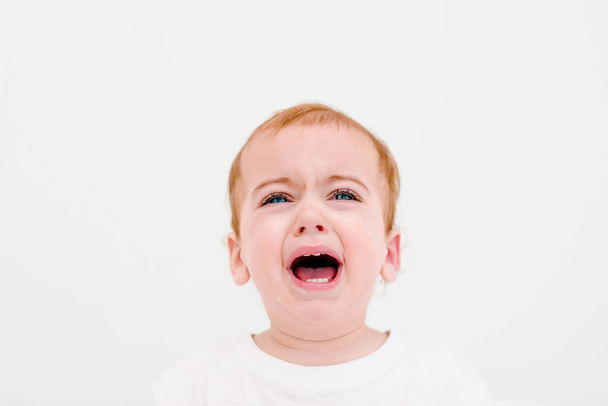 Портрет дитини 1 рік відкритий рот з молочними зубами на білому тлі. Дроль падає з рота
 - Фото, зображення