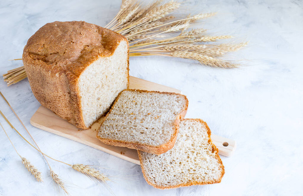 Sült friss házi kenyér egy fa táblán. Élesztőmentes kenyér. Házi készítésű sütemények. - Fotó, kép