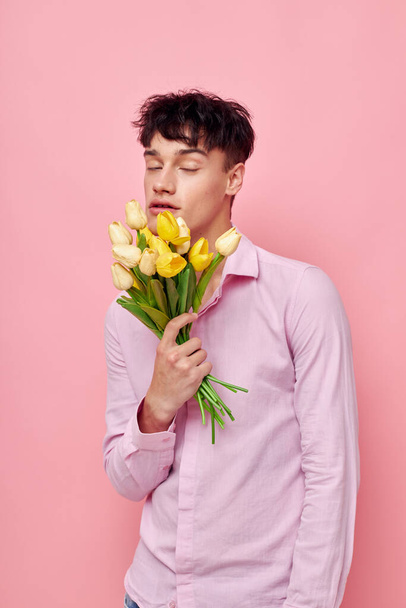 Ένας νεαρός άνδρας μπουκέτο λουλούδια ημερομηνία ειδύλλιο θέτοντας απομονωμένο φόντο αμετάβλητη - Φωτογραφία, εικόνα