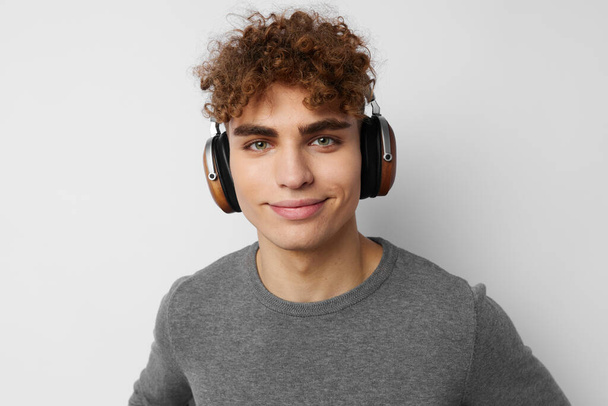 stylish guy listening to music in headphones emotions light background - Foto, Imagem
