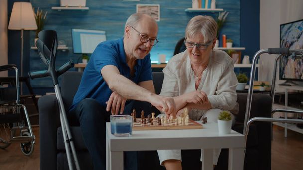 Ηλικιωμένο ζευγάρι παίζει σκάκι επιτραπέζιο παιχνίδι με κομμάτια - Φωτογραφία, εικόνα
