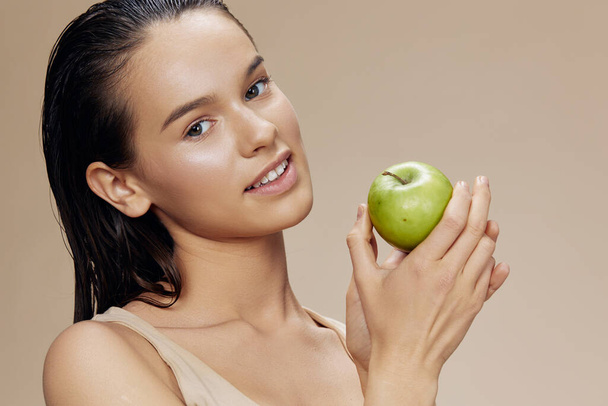 портрет жінки з щасливою посмішкою, що тримає зелене яблуко
  - Фото, зображення