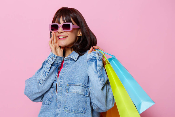 portrait de femme en lunettes de soleil faisant du shopping sur fond isolé. Photo de haute qualité - Photo, image