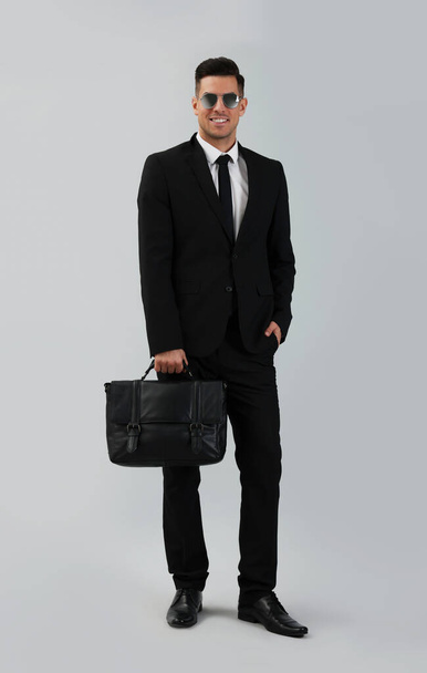 Geschäftsmann mit stilvoller Lederaktentasche auf hellem Hintergrund - Foto, Bild