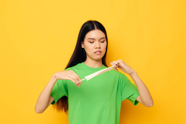Okouzlující mladá asijská žena v zeleném tričku lékařské masky ochrana životního stylu beze změny - Fotografie, Obrázek