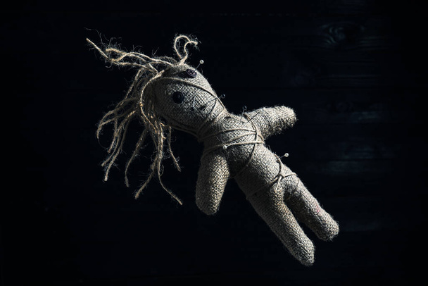 Female voodoo doll with pins on dark background - 写真・画像