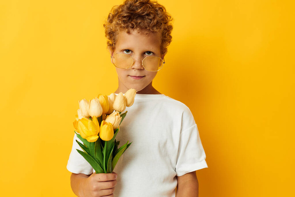 cute boy holding a bouquet of flowers a gift isolated background unaltered - Photo, Image