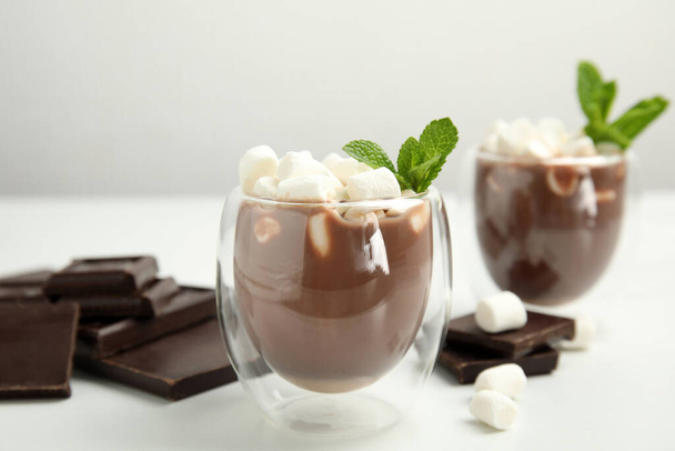 Glasses of delicious hot chocolate with marshmallows and fresh mint on white table - Φωτογραφία, εικόνα