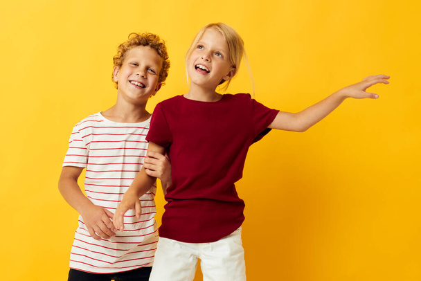 Kleine Kinder stehen nebeneinander und posieren kindliche Gefühle auf farbigem Hintergrund - Foto, Bild