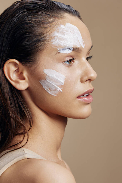 woman applying cream on face on  isolated background. High quality photo - Foto, Imagem