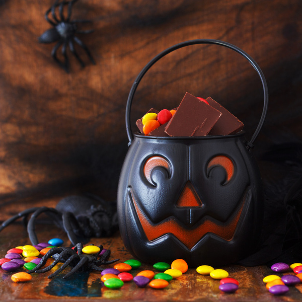 Sweets chocolate candy for Halloween in pumpkin, spider, web - Foto, immagini