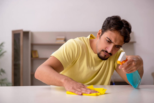 Junger Mann erledigt Hausarbeit zu Hause - Foto, Bild