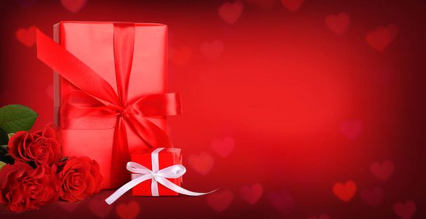 Geschenke zum Valentinstag und Rosen auf rotem Hintergrund mit Platz für Text - Foto, Bild