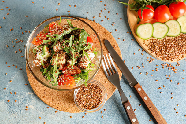Tigela com sementes saudáveis de linho de salada vegetal no fundo de cor - Foto, Imagem