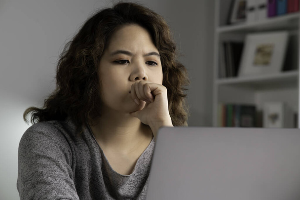 Väsymys ja stressi. Nuori aasialainen nainen istuu etsivät syvälle ajatukseen uupunut ja väsynyt työskennellessään kotona toimistossa kannettavan tietokoneen. Ylirasittunut väsynyt aasialainen naispuolinen opiskelija näyttää uupuneelta ja väsymys tietokonetyön jälkeen - Valokuva, kuva