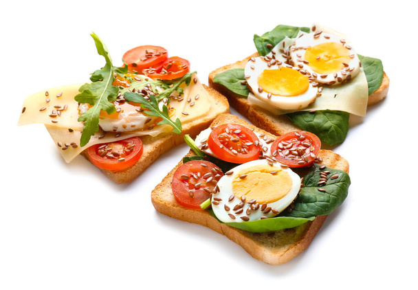 Des toasts savoureux aux œufs et graines de lin sur fond blanc - Photo, image