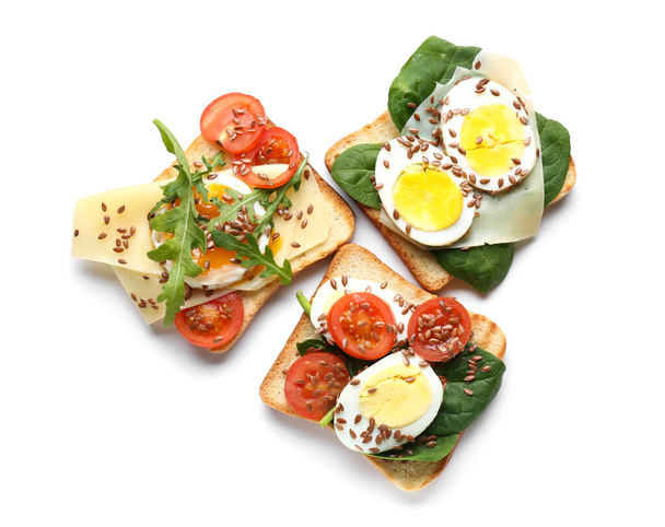 Вкусные тосты с яйцами и семенами льна на белом фоне - Фото, изображение