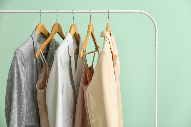 Rack with clean female clothes on green background, closeup - Zdjęcie, obraz