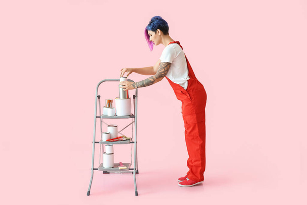 Художница с лестницей и банками на розовом фоне - Фото, изображение