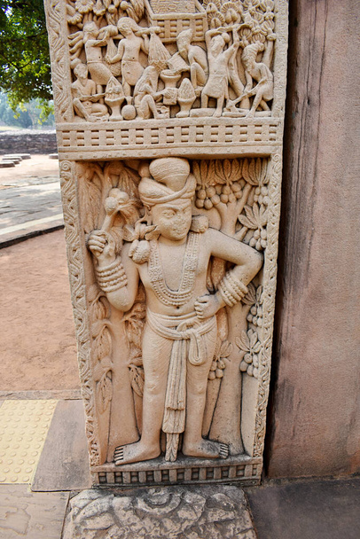 Stupa No 1, East Gateway, Left Pillar, Inside Panel 4: Dvarapala, Clad in dhoti. Hier mit vielen Ornamenten und schweren Ohrringen stehend. Die Große Stupa, Weltkulturerbe, Sanchi, Madhya Pradesh, Indien.  - Foto, Bild