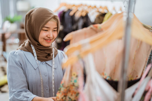 Successful muslim fashion designer checking at her product - Foto, Imagen