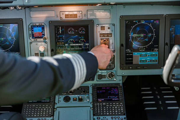 Pilota di linea che utilizza il pannello di controllo nella cabina di pilotaggio degli aeromobili - Foto, immagini