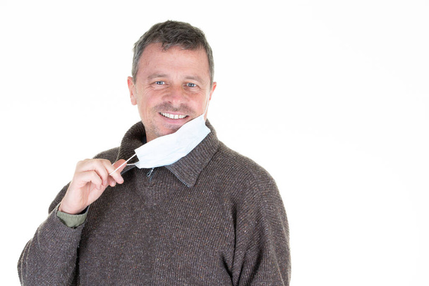человек счастливый веселый улыбка снимает защитную маску Ковид вирус побежден COVID-19 - Фото, изображение