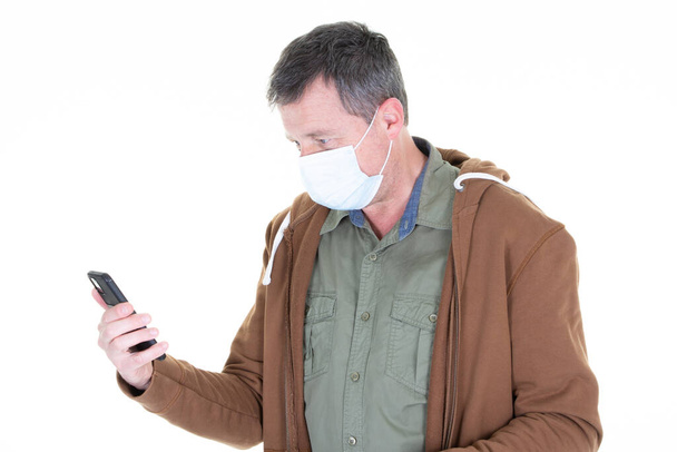 homem olhando telefone celular em máscara cirúrgica rosto protetor vírus Covid COVID-19 - Foto, Imagem