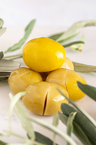 Gelbe Kalamata-Oliven aus nächster Nähe. Bio-Oliven auf einem Marmorboden - Foto, Bild