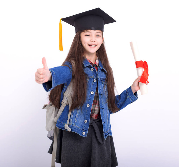 Happy girl student pokazując kciuki w górę i stojąc na białym tle  - Zdjęcie, obraz